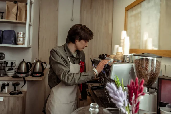 Gutaussehender Mann arbeitet mit professioneller Kaffeemaschine — Stockfoto