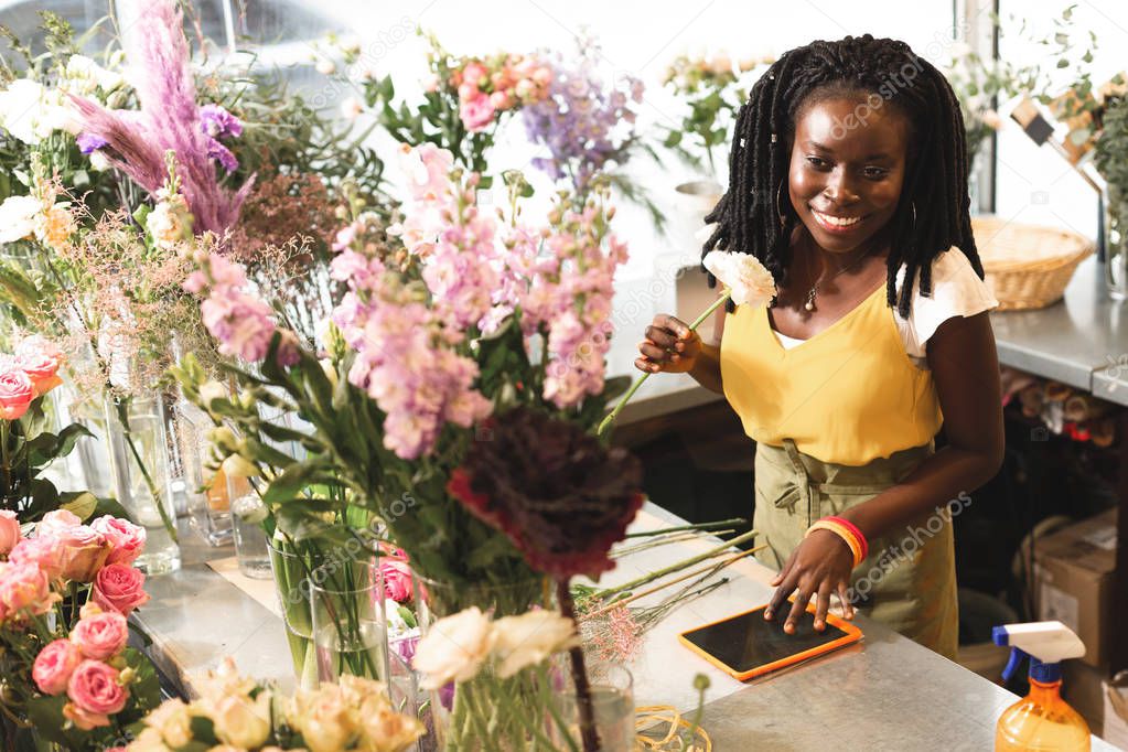 Amazing young shop assistant working with flowers