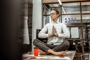 İşyerinde yoga yapan neşeli erkek kişi