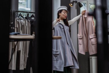 Güzel kız yeni giysiler üzerinde çalışıyor düşünme