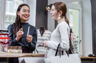 Alışveriş sırasında parfüm seçen iki arkadaş