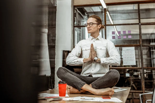 Alegre masculino pessoa fazendo ioga no seu local de trabalho — Fotografia de Stock