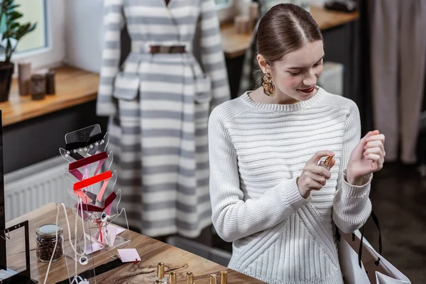 Glimlachend meisje beslissen welke parfum past haar beter — Stockfoto