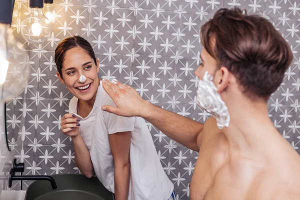 Munter par har det sjovt i deres badeværelse - Stock-foto