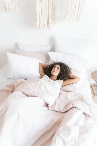 Happy young woman looking upwards at room decoration — Stock Photo, Image