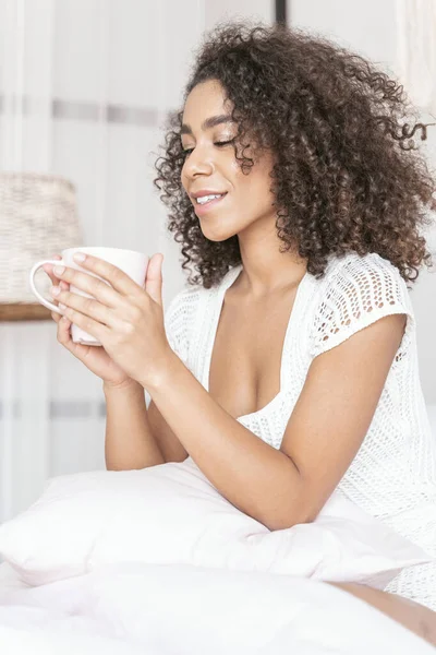 Cheerful curly haired woman looking at cup — 스톡 사진