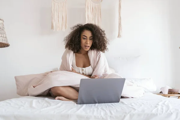 Emocional persona femenina internacional mirando fijamente a su portátil — Foto de Stock