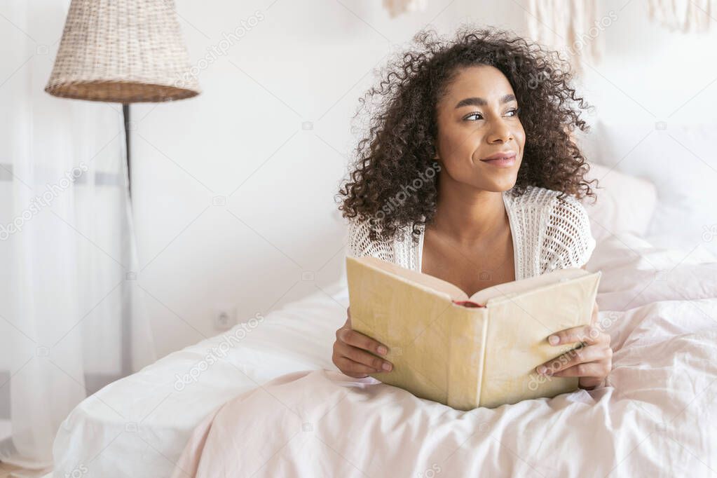 Relaxed female person holding book in both hands