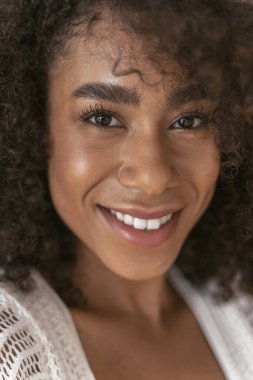 Muhteşem genç esmer kadın kameraya bakıyor.