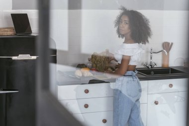 Düşünceli kadın akşam yemeği için sebze doğrayacak.