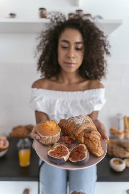 Güzel kadın sırada ne yiyeceğini seçiyor.