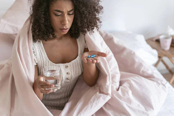 Serious young brunette woman going to take pills — Stock Photo, Image