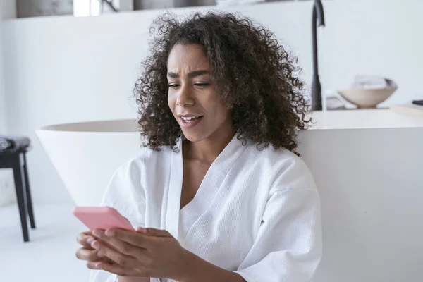 Mujer confundida leyendo sus mensajes de teléfono inteligente — Foto de Stock