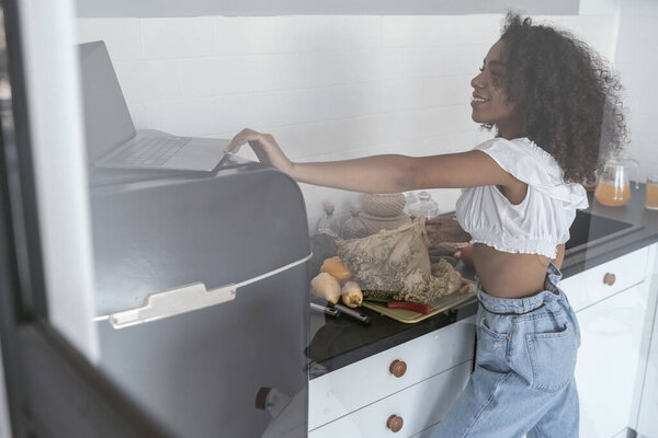 Smiling woman checking the recipe on Internet