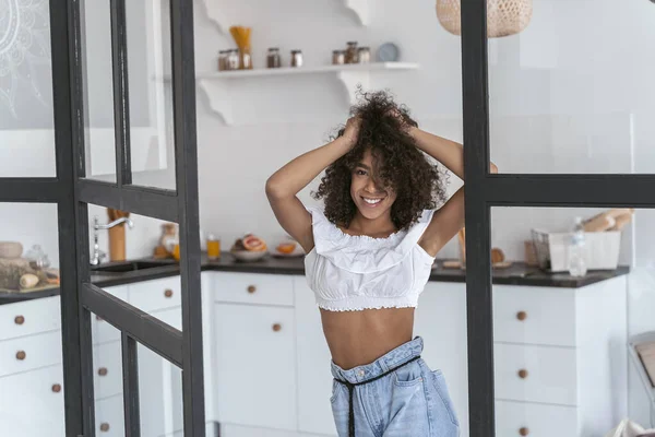 Feliz dama de pie a la entrada de su cocina — Foto de Stock