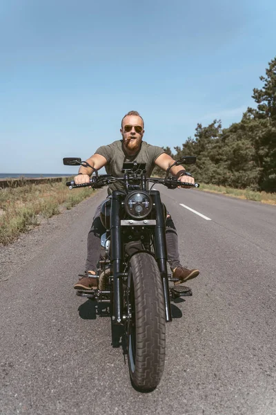 Low angle of an athletic handsome biker riding the motorcycle — Stock Photo, Image