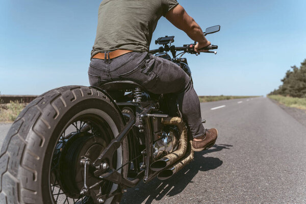 Low angle of a motorcycle and man sitting on it