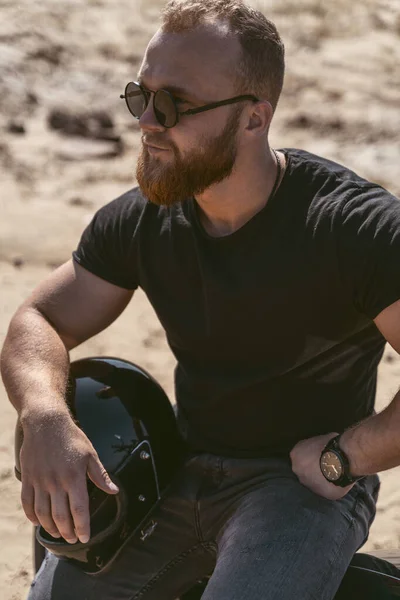 Портрет красивого бородатого байкера, який сидить на своєму велосипеді — стокове фото