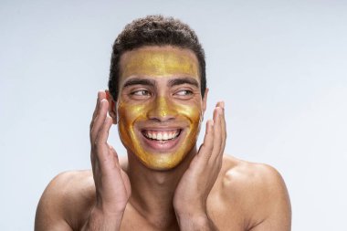 Mutlu yakışıklı adam yüzünü genç tutuyor.