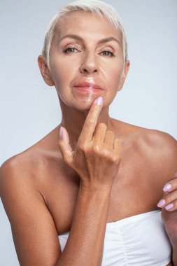 Dudaklarına maske takan çekici olgun bir kadın.