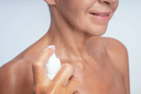 Close up of delighted woman that spraying her neck — Stock Photo, Image