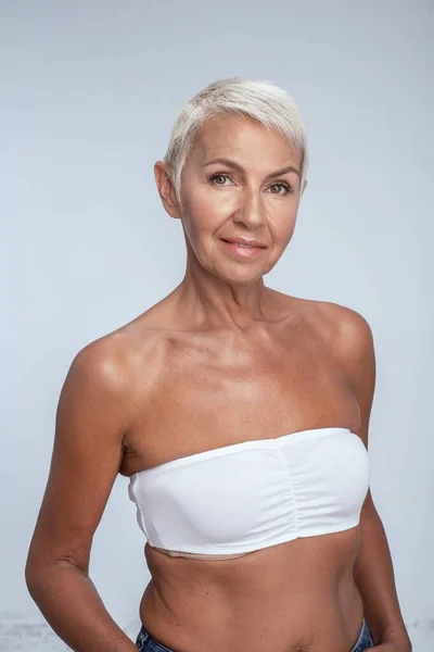 Gorgeous blonde middle aged woman posing in bra — Stock Photo, Image