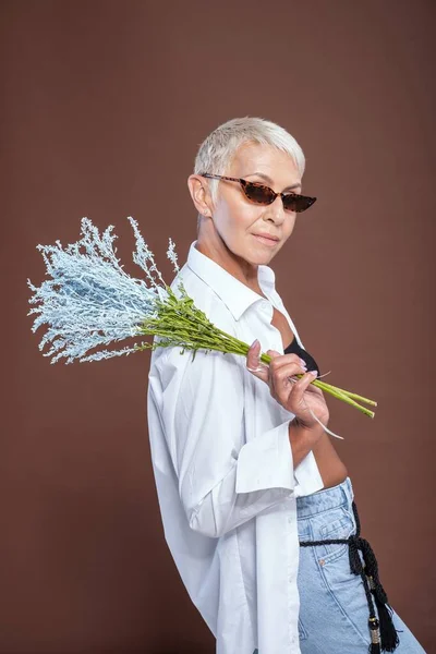 Belle blonde posant à la caméra avec des plantes — Photo