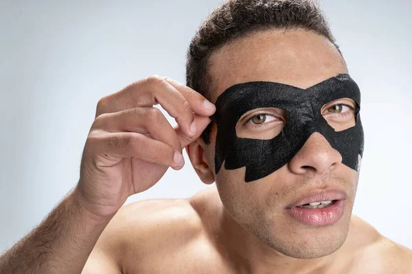 Concentrated young man finishing his beauty procedure — Stock Photo, Image