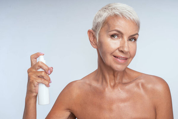 Pleased senior female looking straight at camera