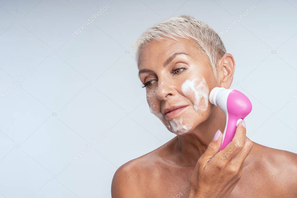 Dreamy blonde woman preparing her skin for makeup