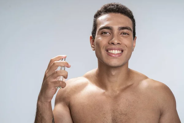 Happy young man enjoying his new perfume — Stock Photo, Image
