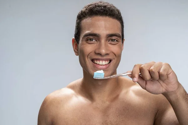 Усміхнений чоловік починає чистити зуби — стокове фото
