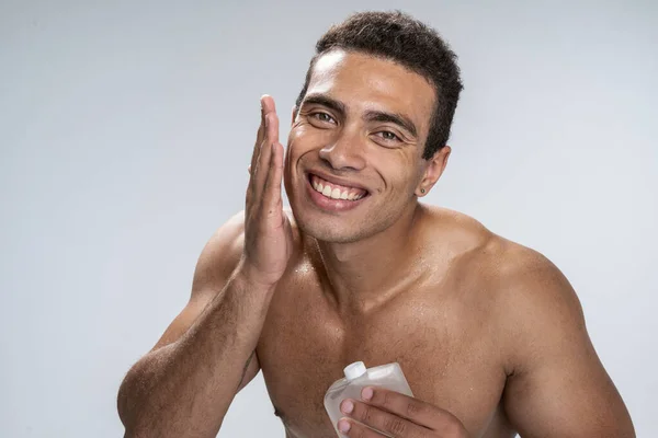 Cheerful male caring of his irritated skin — Stock Photo, Image