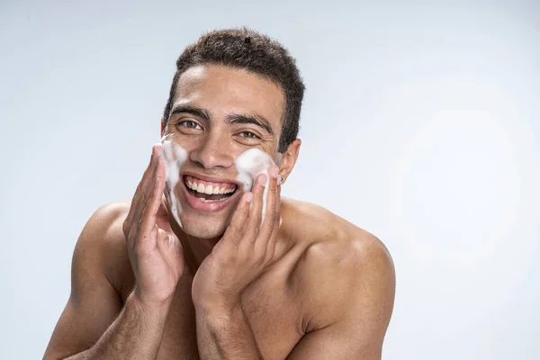 Leende man som bryr sig om sin fläckbenägna hud — Stockfoto