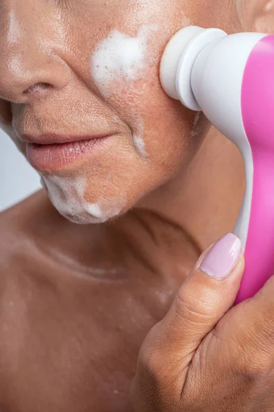 Fotografía enfocada en la mano femenina que sostiene cepillo electrónico —  Fotos de Stock