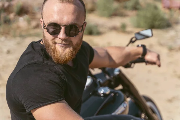 Close up of a handsome bearded man sitting on bike — Stock Photo, Image