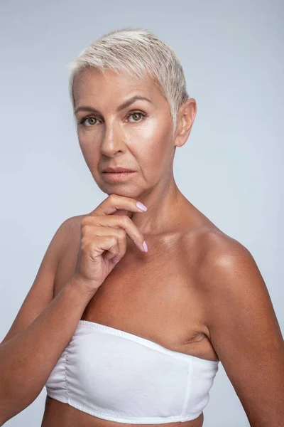 Mujer atractiva posando con una mano en la barbilla — Foto de Stock