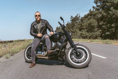 Deri ceketli, motosikletli seksi bir motosikletli.