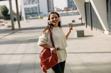 Memnun esmer kız doğrudan kameraya bakıyor.
