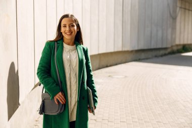 Neşeli esmer kız doğrudan kameraya bakıyor.