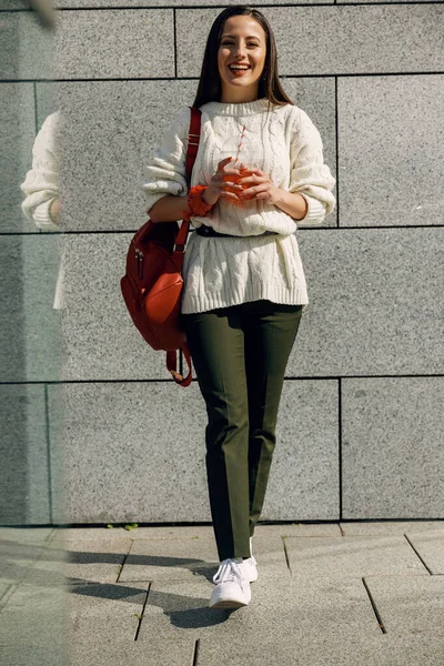 Fröhliche junge Frau geht mit Limonade in der Hand — Stockfoto