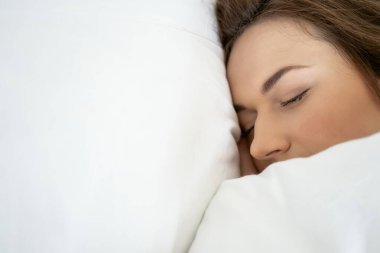 Huzurlu genç bayan yatağında uyuyor.