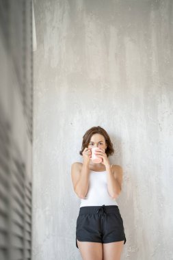 Kafkasyalı genç bir kadın bir fincan kahve içiyor.