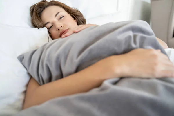 Wanita muda yang tenang berbaring di tempat tidur — Stok Foto