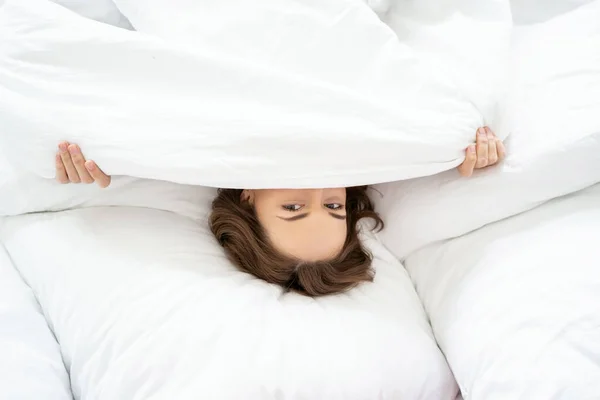 Klidná žena si zakrývá tvář v posteli — Stock fotografie