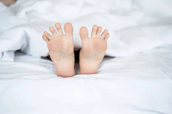 Кавказская молодая женщина ноги лежат в постели — стоковое фото