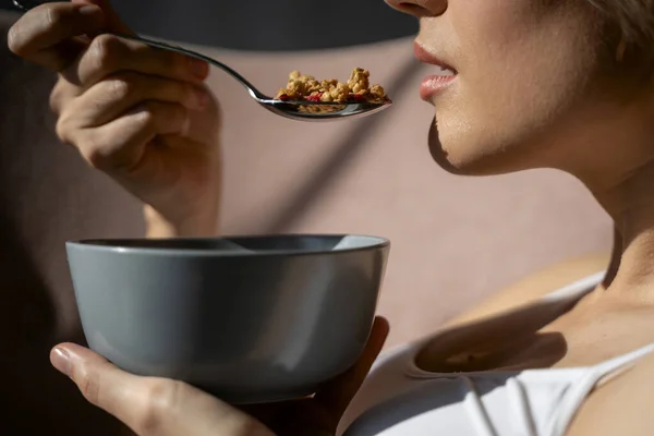 Feminino está comendo uma tigela de cereais — Fotografia de Stock