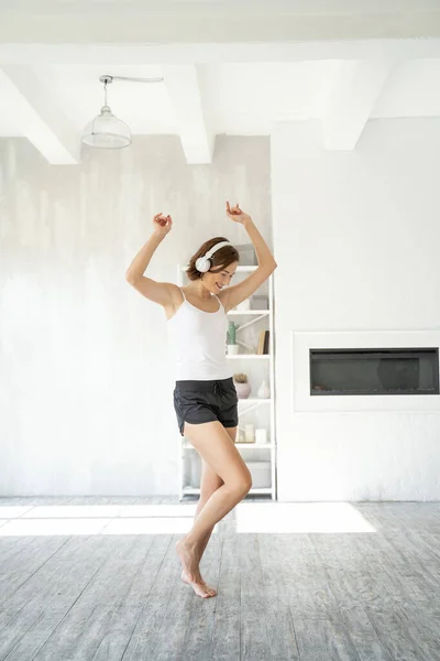 Menina bonito de espírito alto em fones de ouvido dançando em um estúdio — Fotografia de Stock