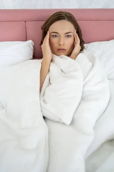 Jolie femme souffrant de maux de tête au lit — Photo