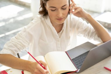 Günlüğüne yazan ciddi bir genç kadın.